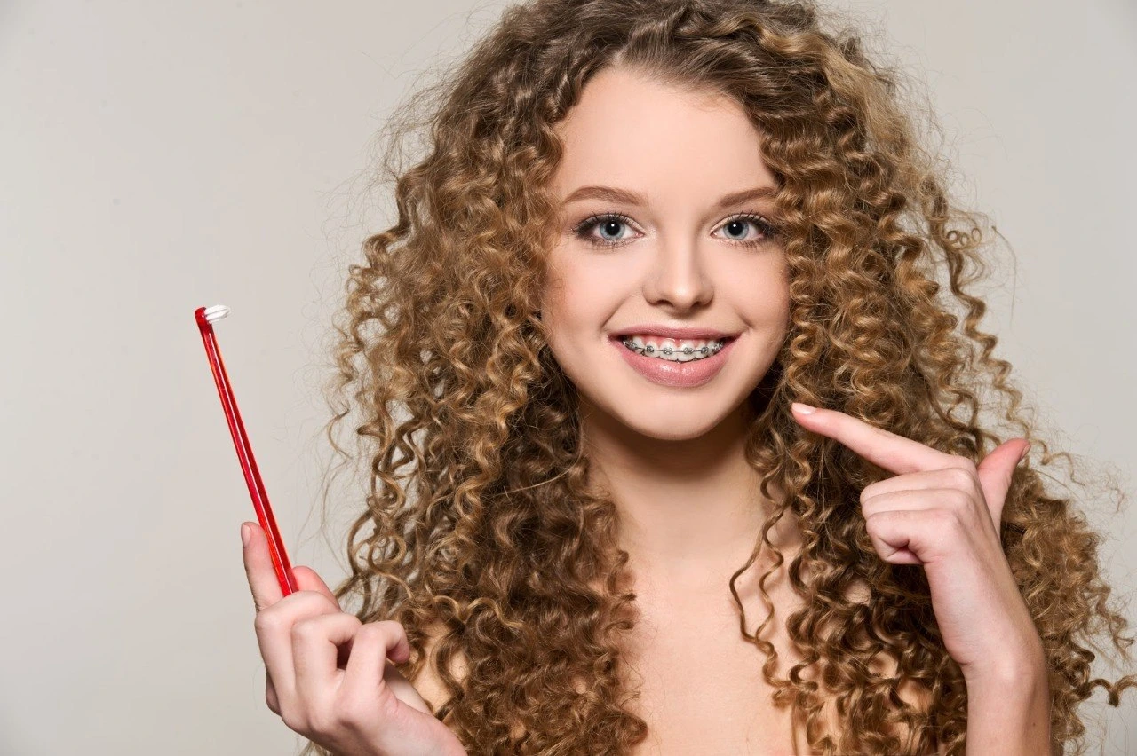 Smiling patient showing her braces